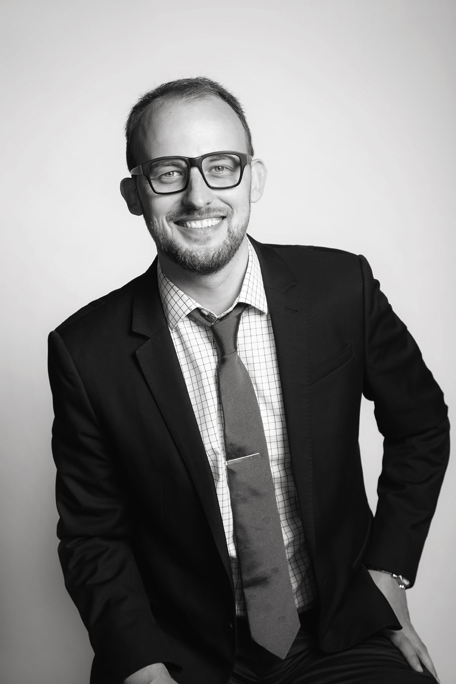 A portrait of a man taken in a studio set up with backdrop and lighting equipment